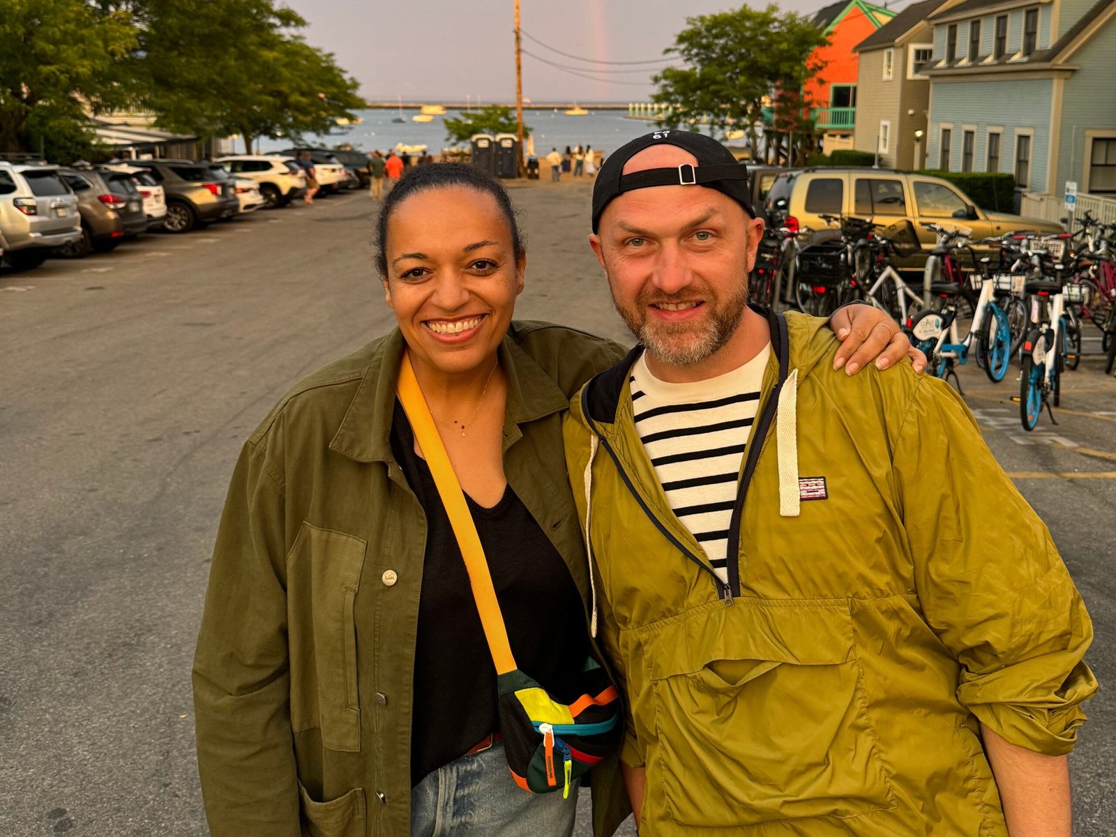 Wade TK and Selena Lounds stand in front of a rainbow.